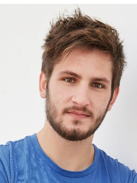 Doctoral Researcher Benji Simpson wearing a blue t-shirt in front of a light background